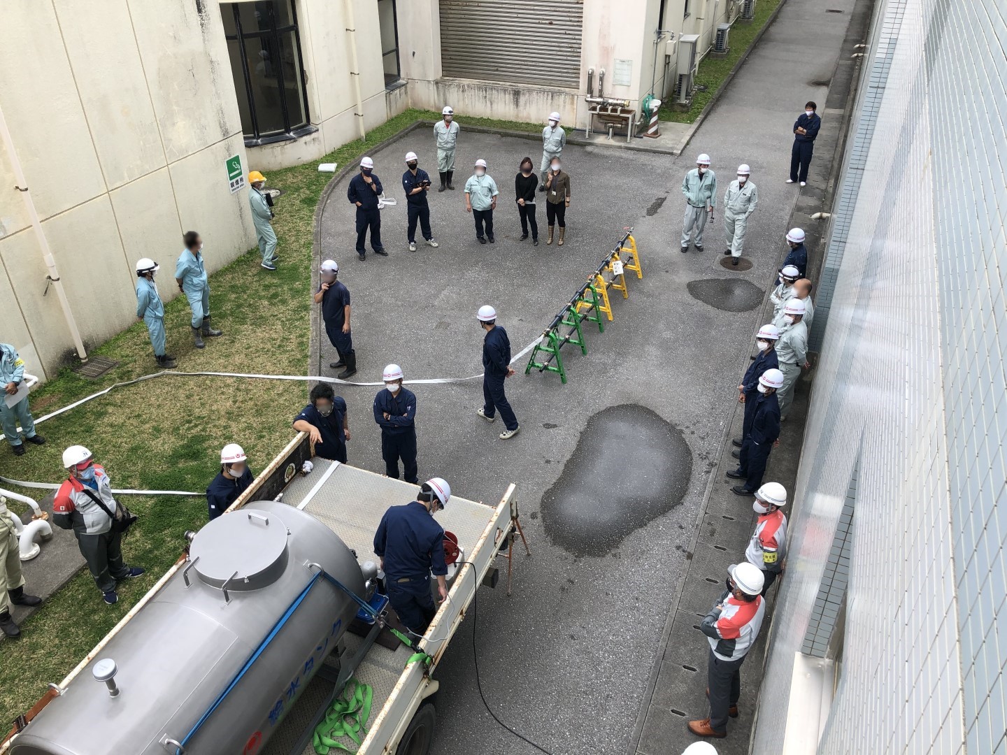 ユニック車に乗せられた給水タンクから給水装置に接続する