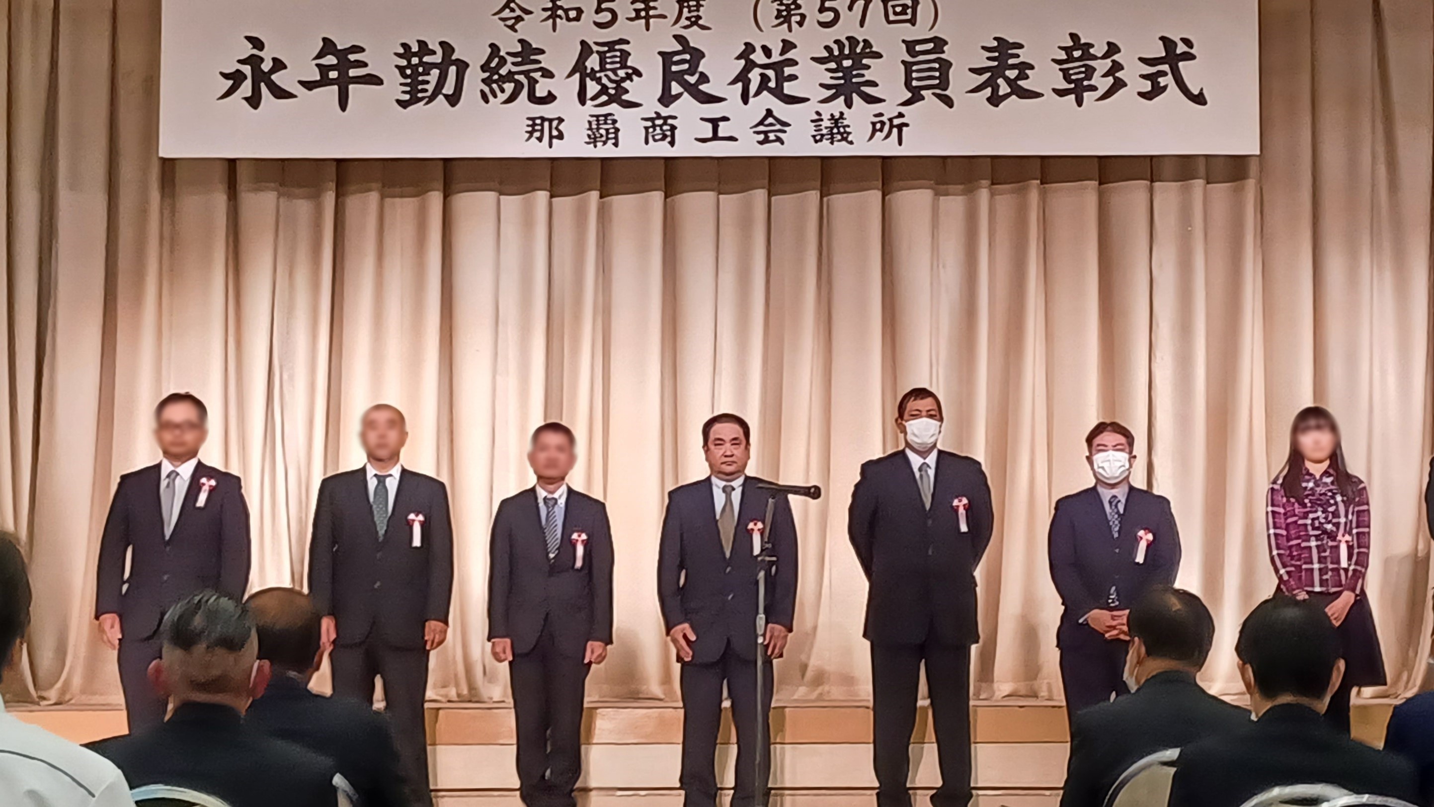 永年勤続優良従業員表彰式で弊社社員3名が並んでいる写真
